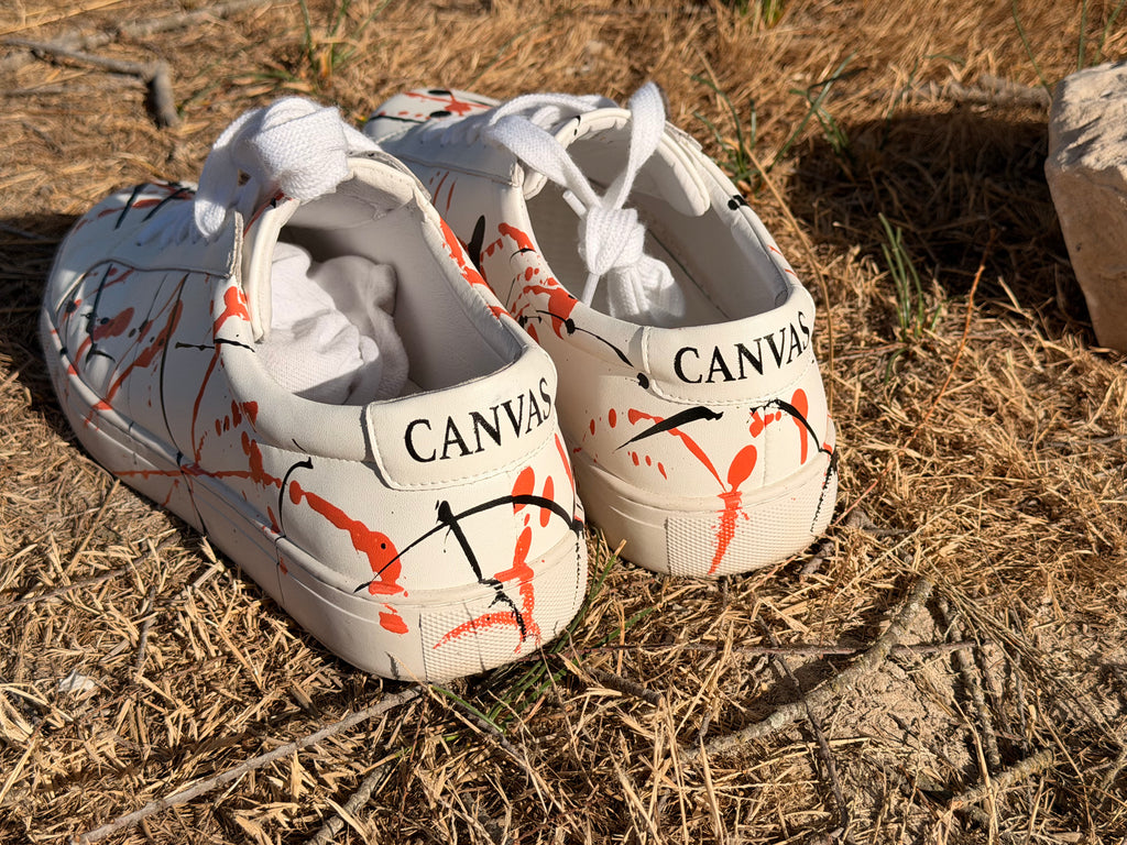 signal sneaker mit handgemachten farbspritzern auf einer Wiese im Urlaub